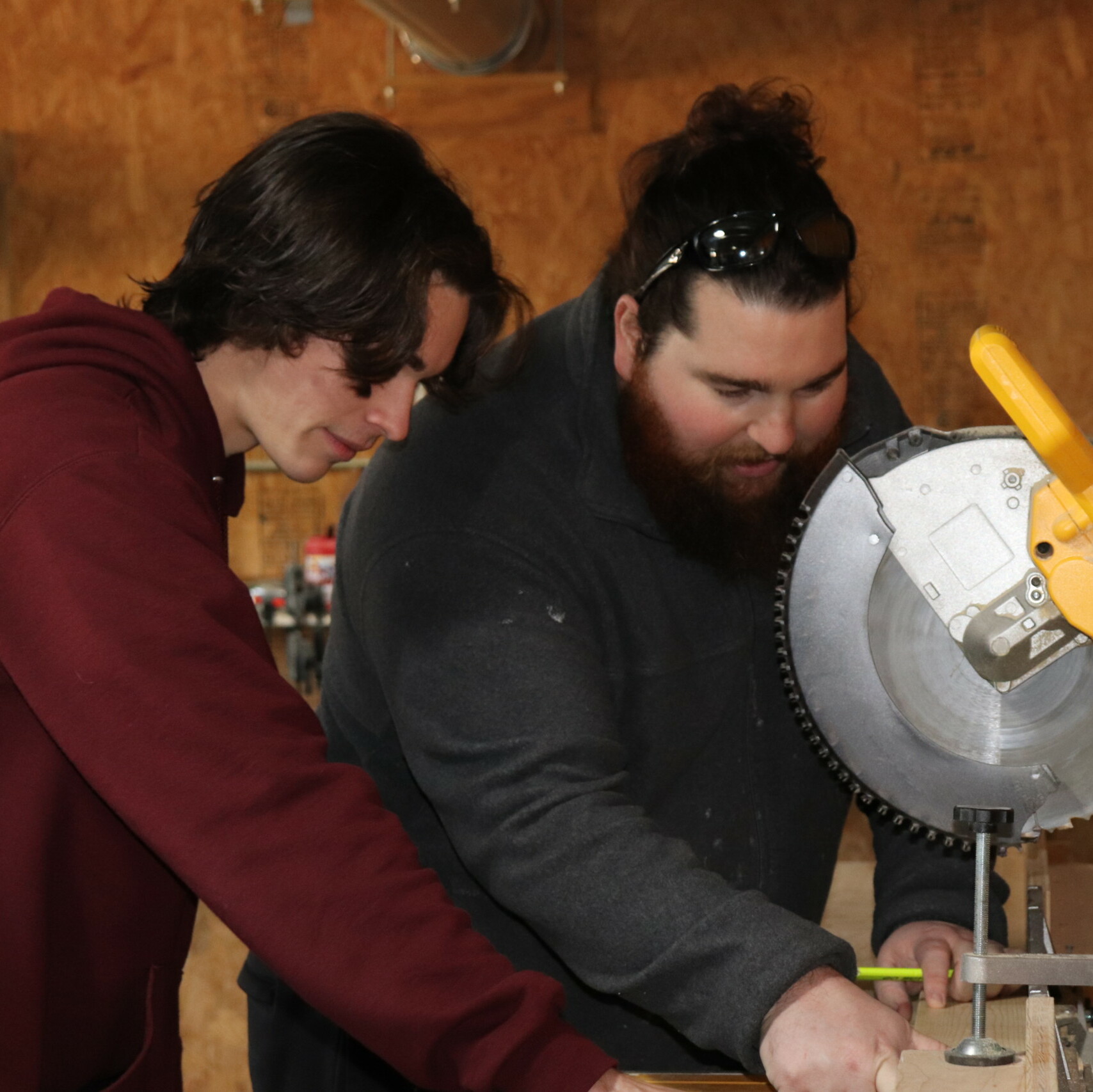 Habitat staff member teaching a volunteer how to use a table saw. 